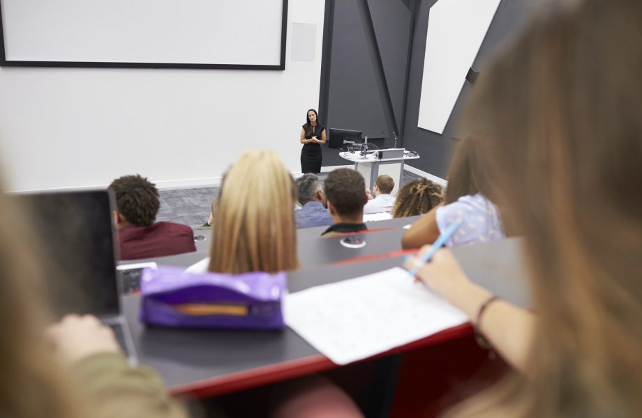 Woman lecturing students in a lecture theatre, student POV